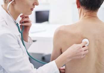 Female doctor examining an old patient.